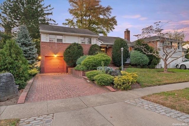 view of front of property with a garage and a lawn