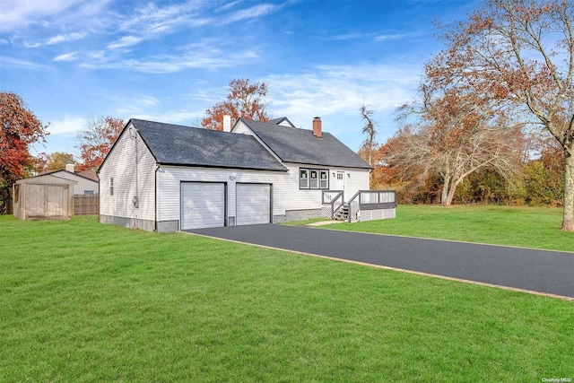 88 Jefferson Dr, Mastic Beach, NY 11951 - view of front of house with driveway, a front yard, a chimney, an attached garage, and a wooden deck