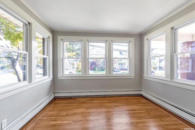 unfurnished sunroom featuring a healthy amount of sunlight and a baseboard heating unit