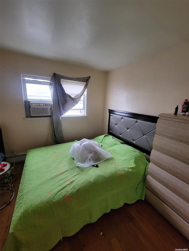 bedroom with hardwood / wood-style floors, cooling unit, and a baseboard radiator