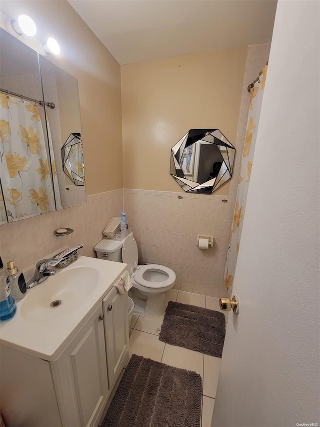 bathroom featuring tile patterned flooring, vanity, tile walls, and toilet