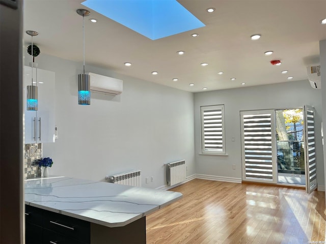 bar with a wealth of natural light, pendant lighting, radiator heating unit, and a skylight