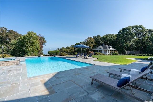 view of swimming pool featuring an outdoor structure, a patio area, a yard, and an in ground hot tub