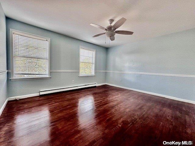 empty room with a textured ceiling, ceiling fan, dark hardwood / wood-style flooring, and baseboard heating