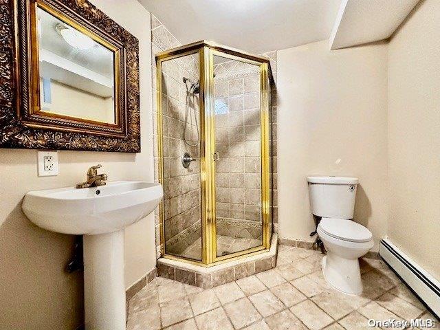 bathroom featuring tile patterned floors, a baseboard radiator, toilet, and a shower with door