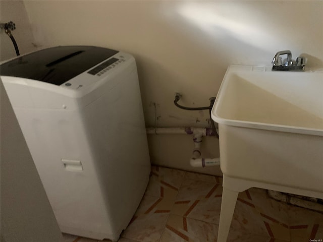 washroom featuring washer / clothes dryer, sink, and light tile patterned floors