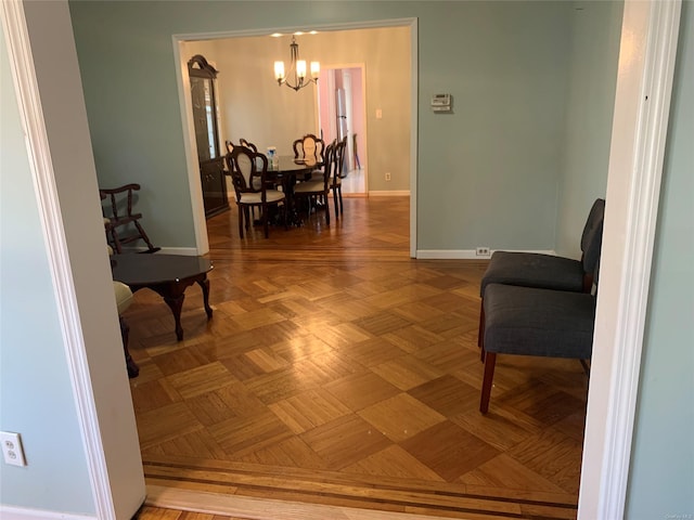 interior space featuring parquet flooring and a chandelier