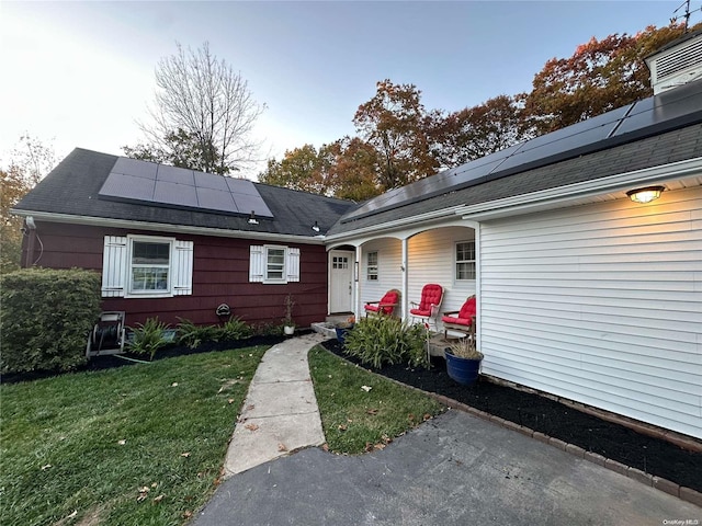 exterior space featuring solar panels and a lawn