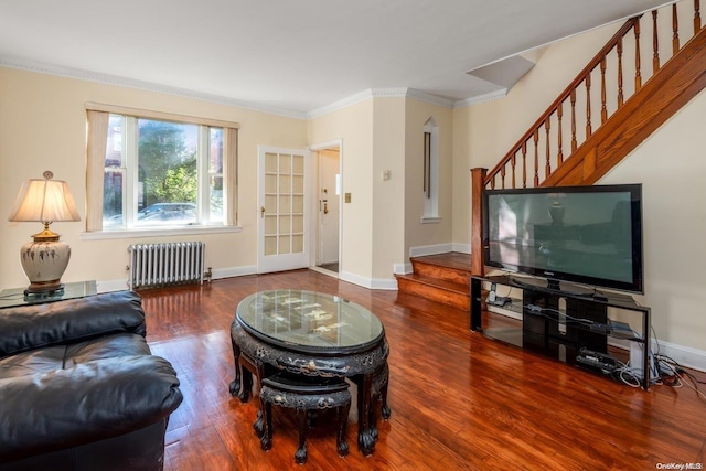 living room featuring hardwood / wood-style floors, radiator heating unit, and crown molding