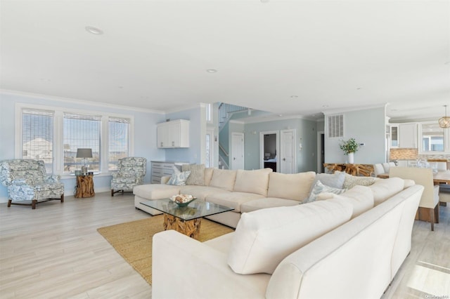 living room with crown molding and light hardwood / wood-style floors