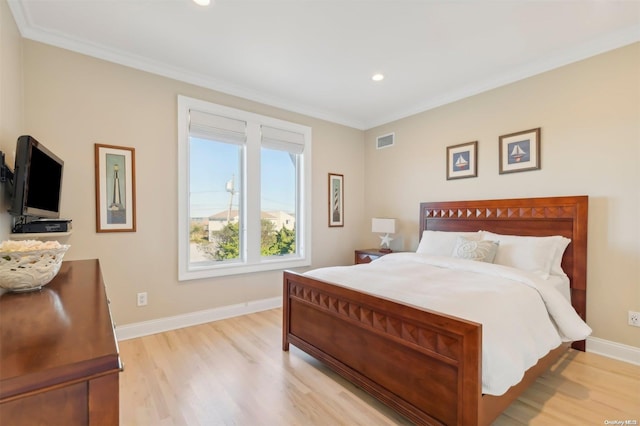 bedroom featuring light hardwood / wood-style floors and crown molding