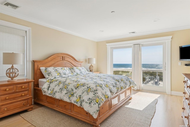 bedroom with light wood-type flooring and crown molding