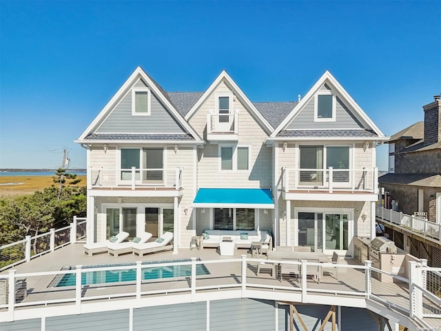 back of house featuring a balcony and an outdoor hangout area