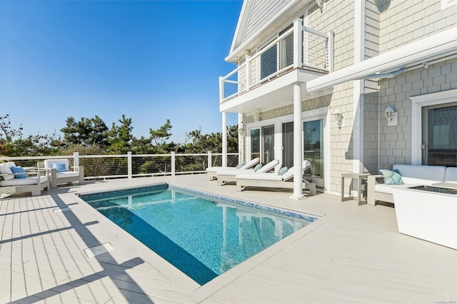 view of swimming pool featuring an outdoor living space and a deck