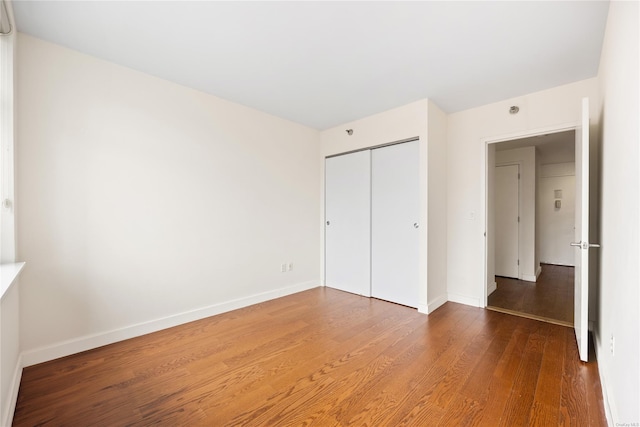 unfurnished bedroom with hardwood / wood-style flooring and a closet