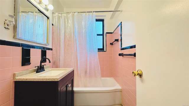 bathroom with shower / tub combo with curtain, vanity, and tile walls