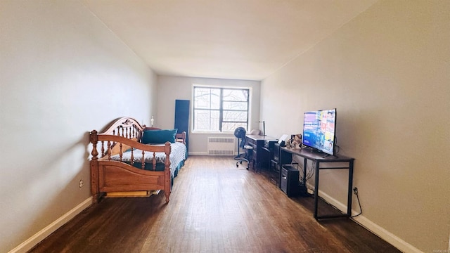 bedroom featuring radiator and dark hardwood / wood-style floors