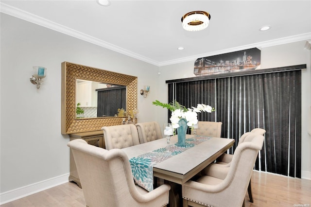 dining room featuring ornamental molding and light hardwood / wood-style flooring