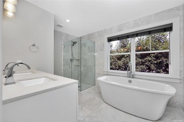 bathroom featuring vanity and independent shower and bath