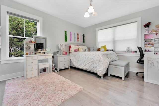 bedroom featuring light hardwood / wood-style floors and an inviting chandelier