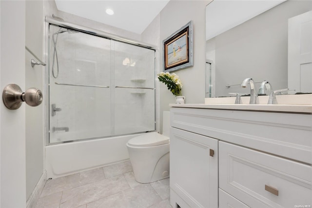 full bathroom with vanity, toilet, and bath / shower combo with glass door