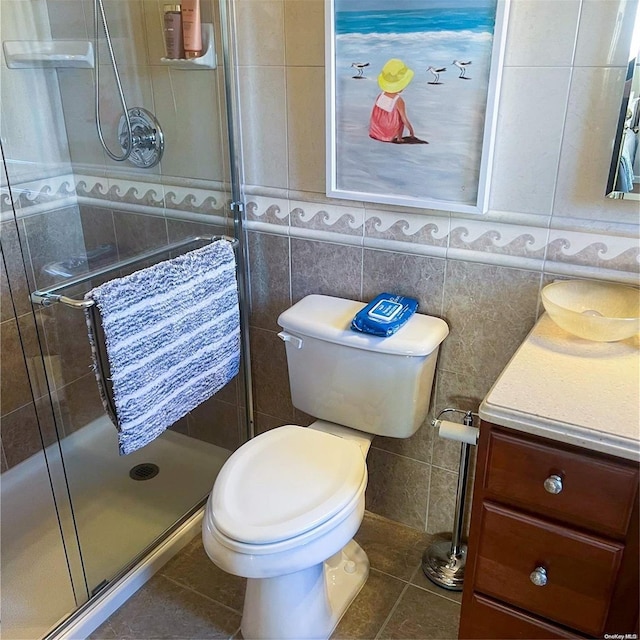 bathroom with tile patterned floors, toilet, tile walls, and walk in shower