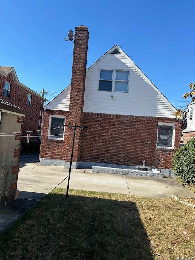 rear view of house with a lawn and a patio