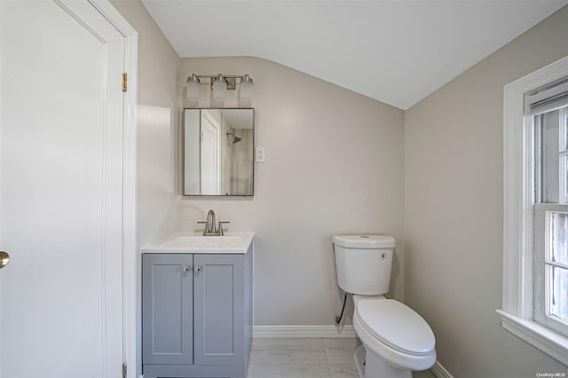 bathroom featuring plenty of natural light, toilet, vanity, and vaulted ceiling