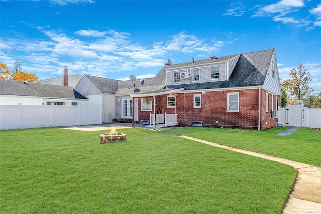 rear view of house with a patio, an outdoor fire pit, and a lawn