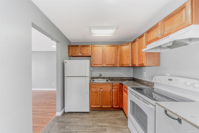 kitchen featuring sink, light hardwood / wood-style floors, and white appliances