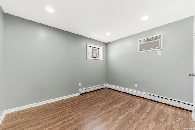 empty room featuring a wall unit AC and hardwood / wood-style flooring