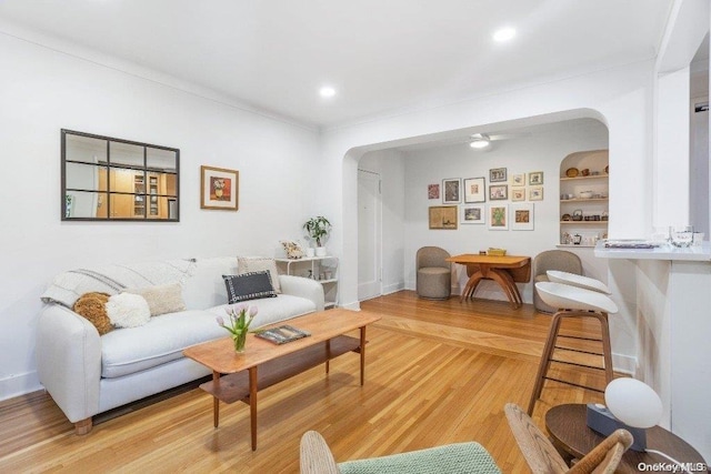 living room with built in shelves and light wood-type flooring