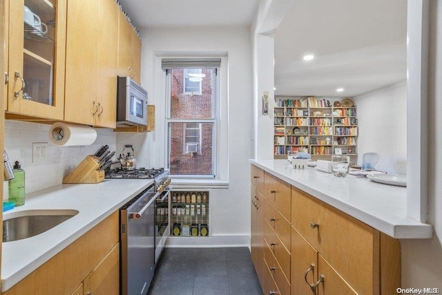 kitchen featuring backsplash, stainless steel appliances, dark tile patterned flooring, and sink