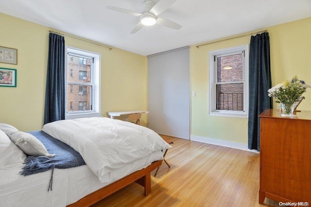 bedroom with light hardwood / wood-style floors and ceiling fan