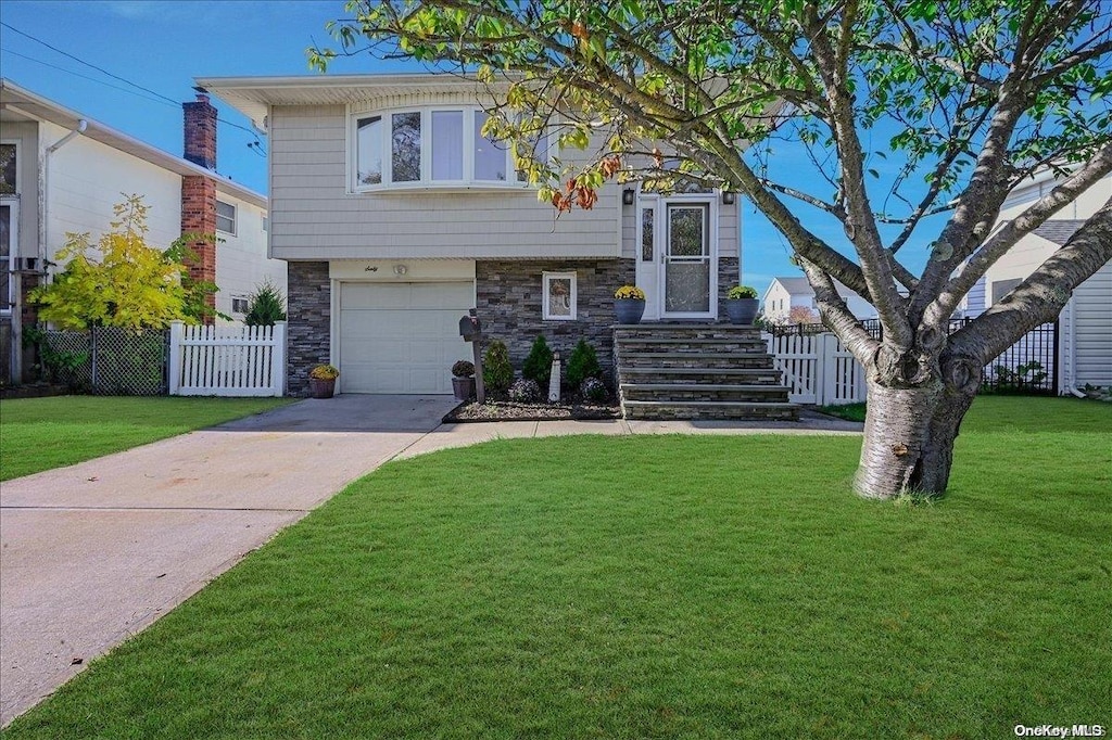 view of front of home with a front yard and a garage