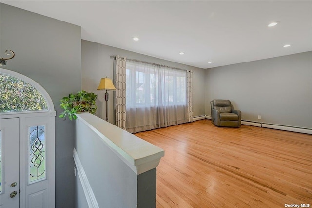 living area featuring a baseboard radiator and light wood-type flooring