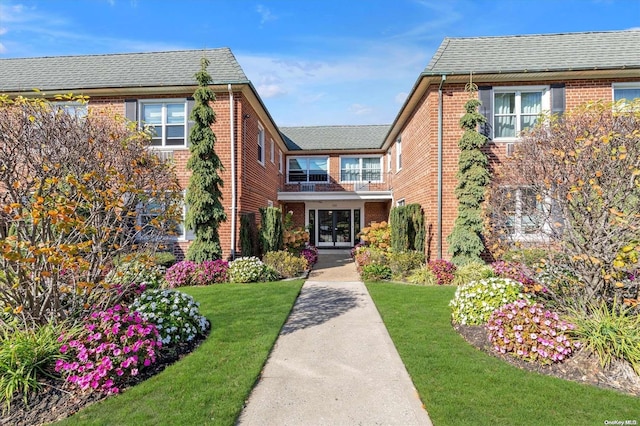 view of front of property with a balcony and a front yard