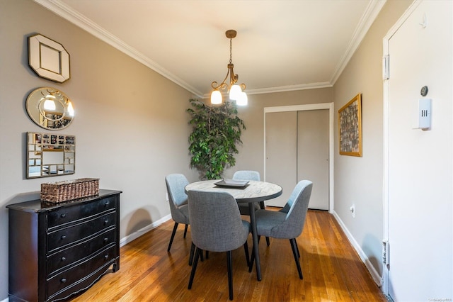 dining room with a chandelier, wood-type flooring, and ornamental molding