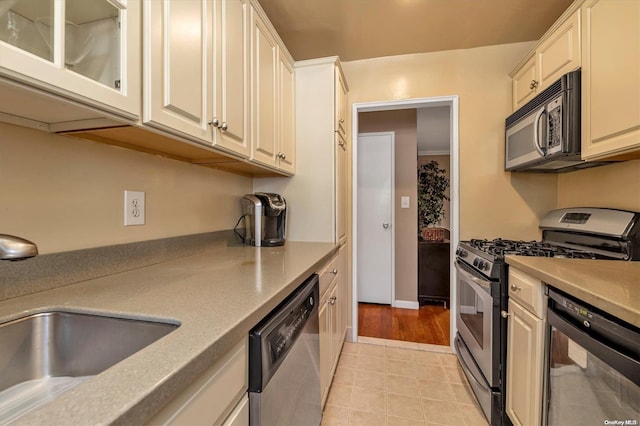 kitchen with stainless steel appliances, light hardwood / wood-style flooring, and sink