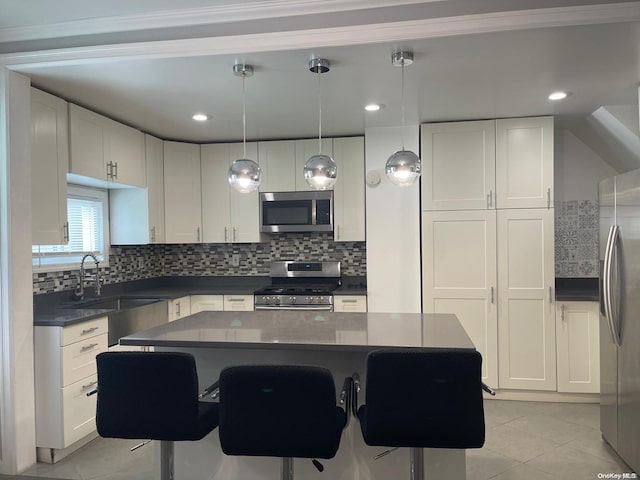 kitchen featuring a center island, sink, hanging light fixtures, white cabinetry, and stainless steel appliances