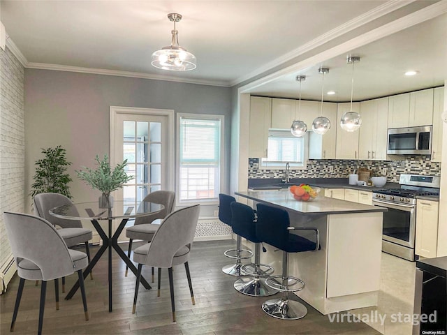 kitchen with white cabinetry, hanging light fixtures, and appliances with stainless steel finishes