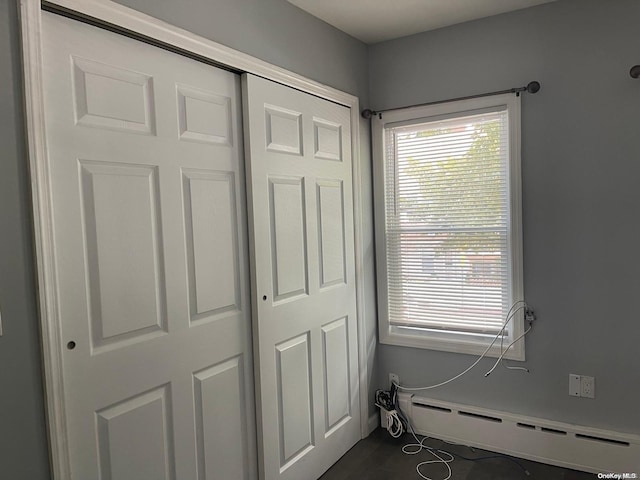 interior space with a baseboard radiator and a closet