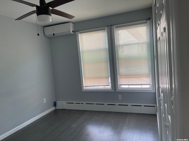 spare room featuring plenty of natural light, dark hardwood / wood-style flooring, an AC wall unit, and baseboard heating