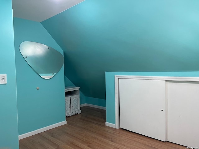 bonus room with light hardwood / wood-style floors and vaulted ceiling