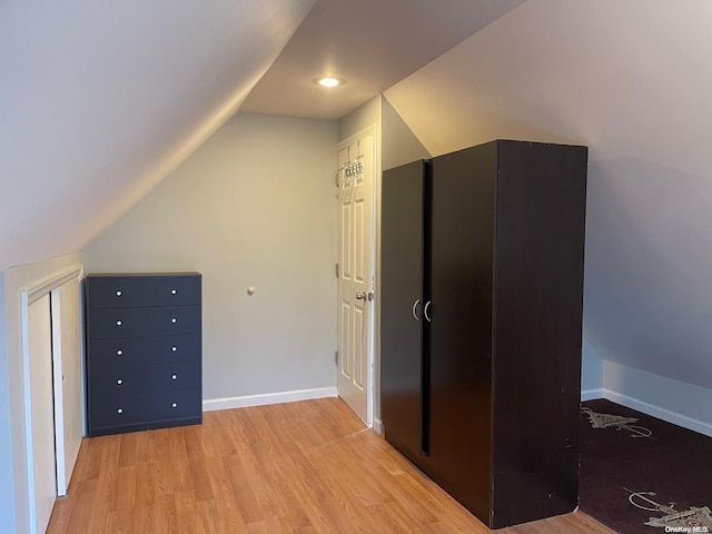 additional living space featuring lofted ceiling and light hardwood / wood-style flooring