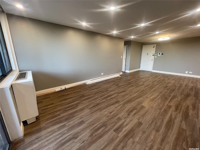 spare room with dark hardwood / wood-style floors and radiator