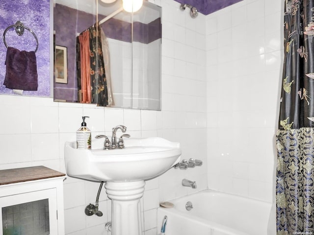 bathroom with shower / bath combo with shower curtain and tile walls