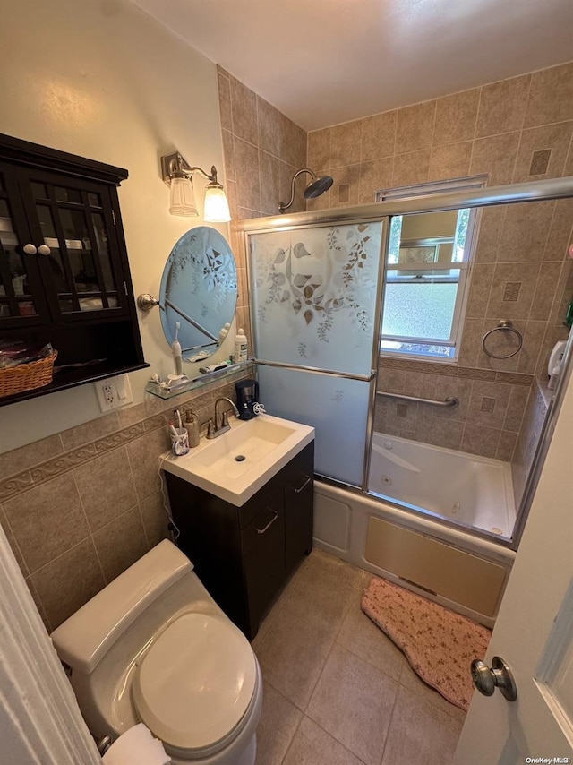 full bathroom featuring tile patterned floors, bath / shower combo with glass door, vanity, and toilet