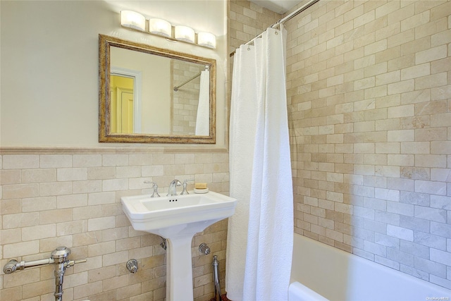 bathroom featuring shower / bathtub combination with curtain and tile walls