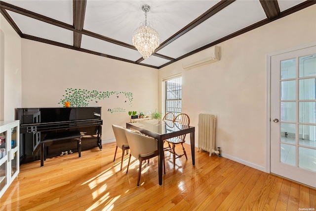 dining area featuring light wood-type flooring, radiator heating unit, a wall unit AC, and a chandelier